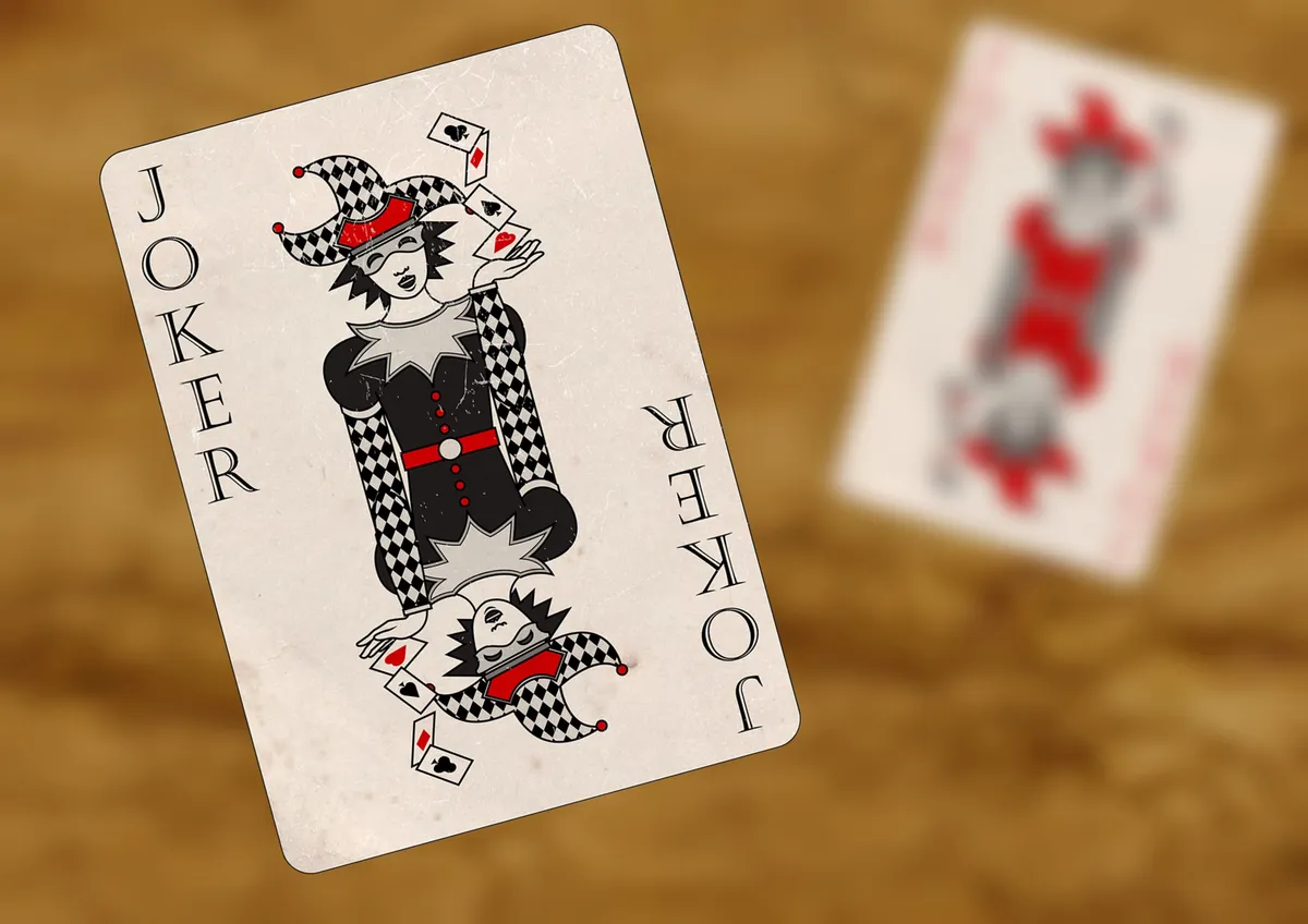 A playing card: the black joker. The red joker is out of focus in the background.